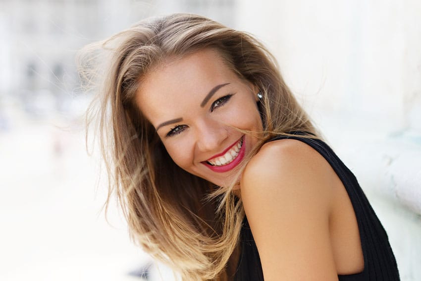 attractive woman in black evening dress shows off her sexy smile