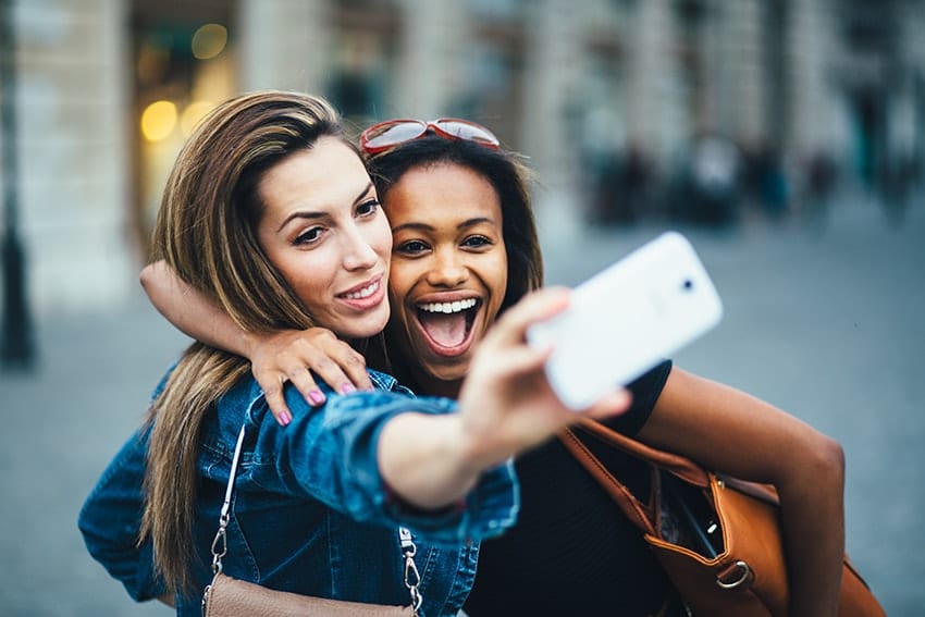 Two friends enjoy a laugh while taking a selfie. Social media is great, but with changes to Instagram, you may now have to show off your true smile?