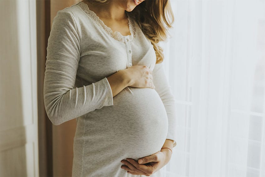 an Expectant Mother holds her stomach